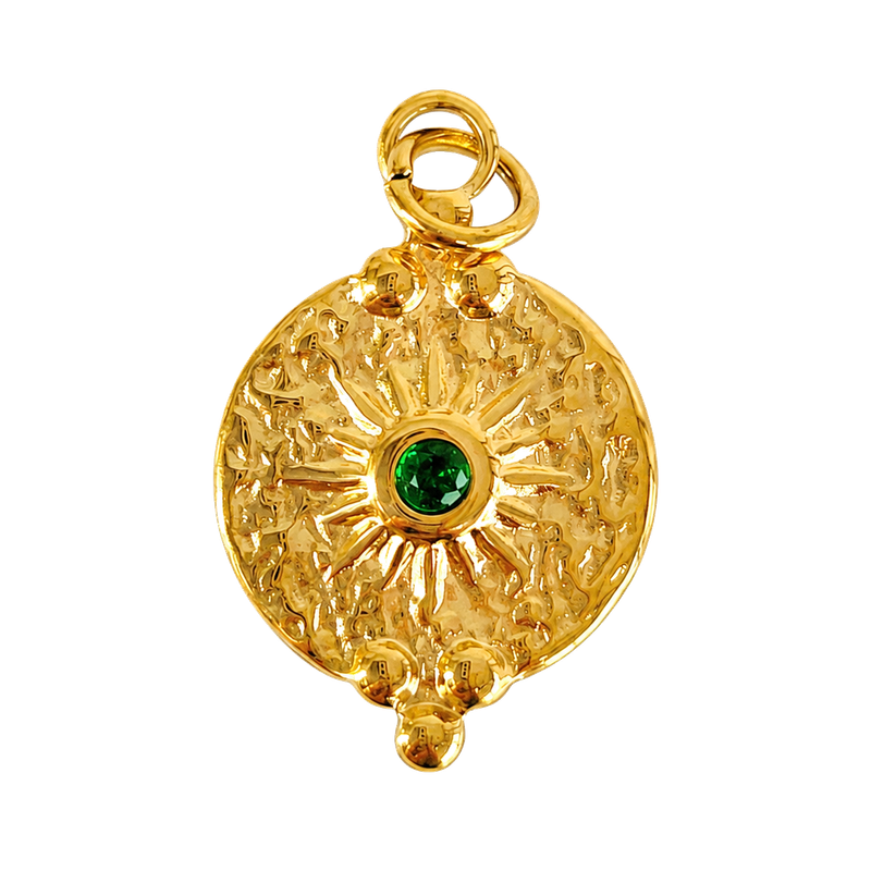 Textured gold-tone sun medallion charm with deep green center crystal