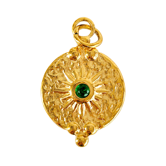 Textured gold-tone sun medallion charm with deep green center crystal