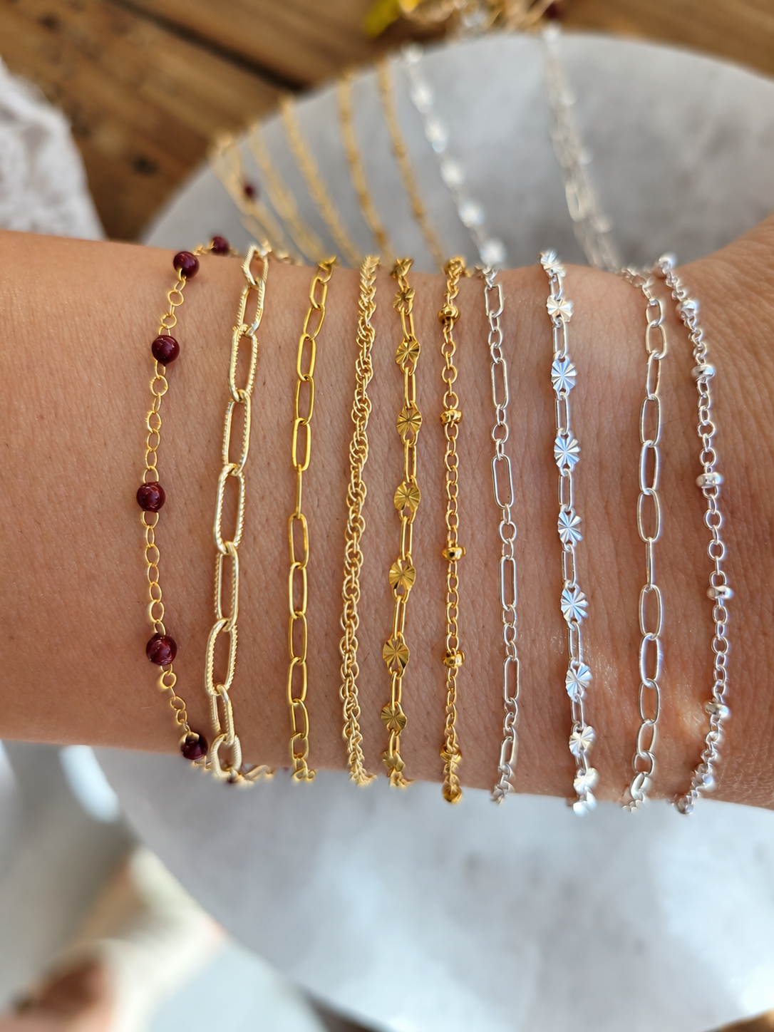 A stack of gold and silver permanent bracelets on a wrist
